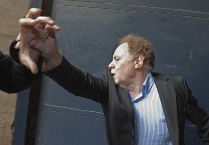 Alan Rosenberg of the Church of Scientology Paris, pushes back reporters as he leaves court. Photo: Reuters