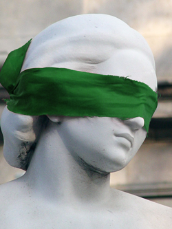 Image of a femaie statue with a green blindfold on